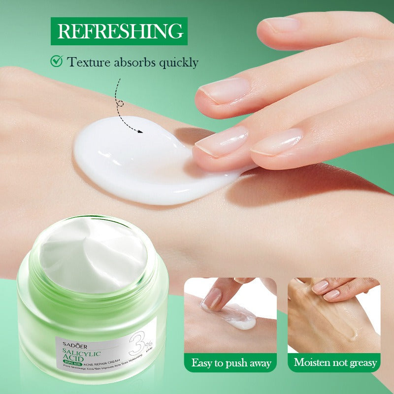 Hand applying cream to wrist with product jar on green background